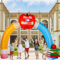 Inflatable pencil archway with an apple sign in front of a school